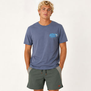 A man wearing a slate blue t-shirt with a 'Chlax born to Fish' logo on the left chest, paired with dark green athletic shorts, against a plain white studio background.