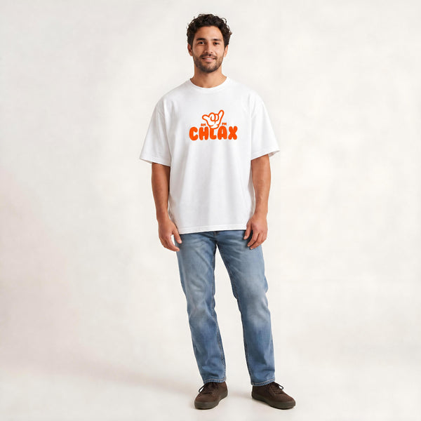 A man wearing a white short-sleeve t-shirt with an orange 'CHLAX' logo on the chest, paired with blue jeans and brown shoes, standing against a light off-white studio background.