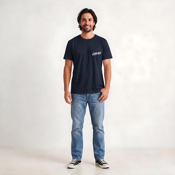 A man wearing a dark navy blue t-shirt with a white 'CHLAX' logo on the left chest, paired with light blue jeans and black sneakers, standing against a light gray studio background.