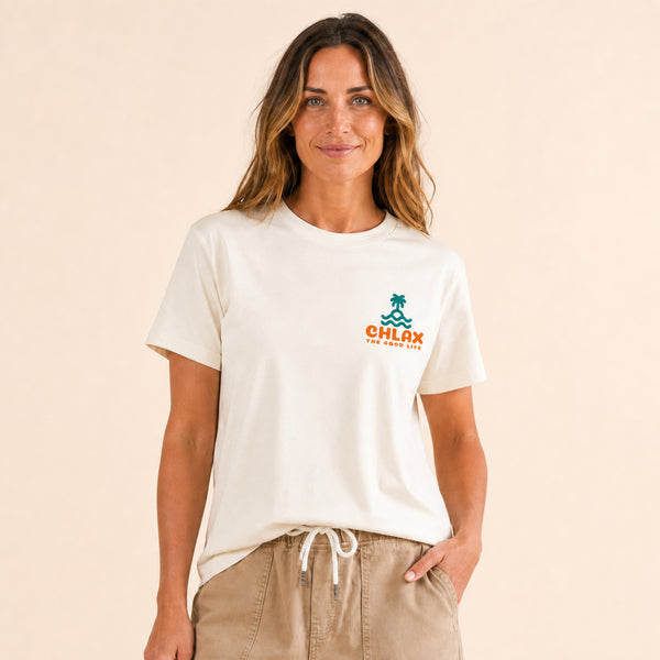 A woman wearing a cream-colored short-sleeve t-shirt with a small green and orange 'CHLAX' logo on the left chest, paired with khaki drawstring pants, against a solid beige background.