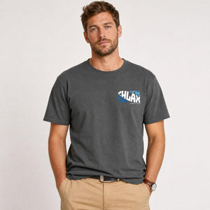 A man wearing a dark charcoal gray crewneck t-shirt with a small 'CHLAX' logo on the left chest, paired with khaki pants, standing against a light gray studio background.