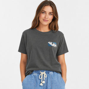 A woman wearing a dark gray washed short-sleeve t-shirt with a small 'CHLAX' graphic on the left chest, paired with light blue denim drawstring pants, against a plain white background.