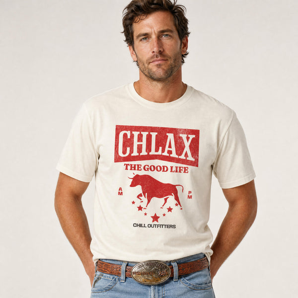 A man wearing a cream-colored graphic t-shirt with a red bull design and the text 'CHLAX THE GOOD LIFE' and 'CHILL OUTFITTERS', paired with blue jeans and a brown belt, against a plain light background.