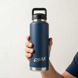 A hand holding a dark blue insulated water bottle with a black lid and silver accents. The bottle features the brand name 'CHLAX' printed in white near the bottom.