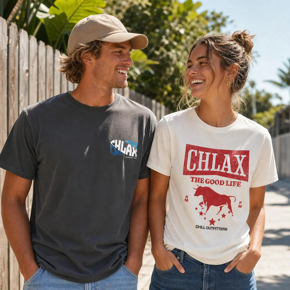 Two models outdoors wearing CHLAX brand t-shirts. The man on the left wears a dark charcoal gray t-shirt with a small blue and white logo on the left chest.