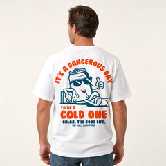 A man shown from the back wearing a white graphic t-shirt with a cartoon character and orange text that reads 'IT'S A DANGEROUS DAY TO BE A COLD ONE' and 'CHLAX. THE GOOD LIFE.