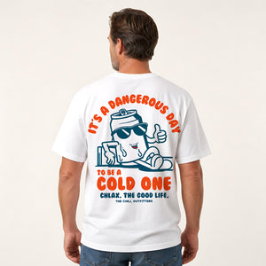A man shown from the back wearing a white graphic t-shirt with a cartoon character and orange text that reads 'IT'S A DANGEROUS DAY TO BE A COLD ONE' and 'CHLAX. THE GOOD LIFE.