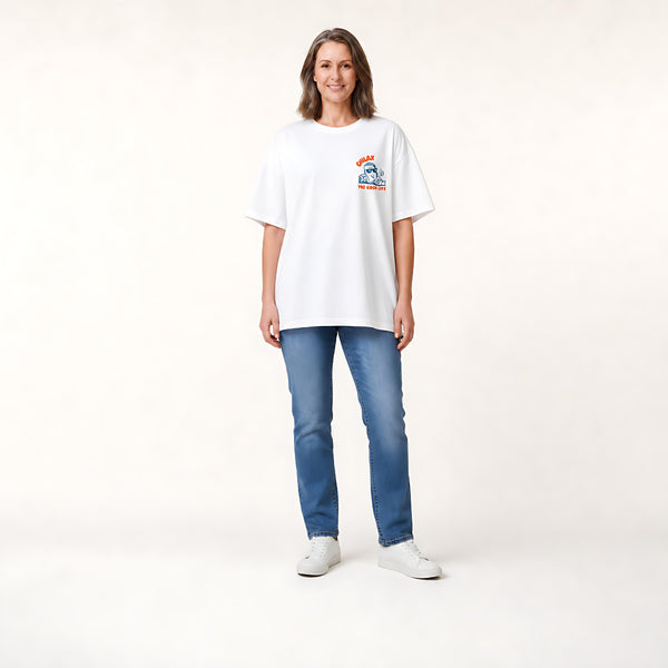 A woman shown from the back wearing a white graphic t-shirt with a cartoon character and orange text that reads 'CHLAX. THE GOOD LIFE.