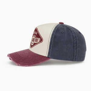 A three-panel baseball cap with a washed cream front panel, dark blue denim-style side panels, and a distressed maroon brim. A maroon diamond-shaped patch on the front reads 'CHLAX WILD AND FREE'.