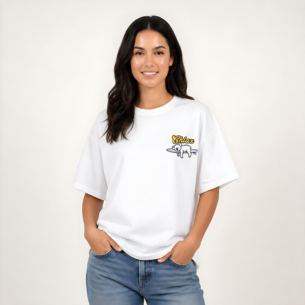A woman viewed from the back wearing a white graphic T-shirt with a large surf-themed print and blue jeans, against a plain light background.