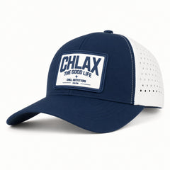 A navy blue and white trucker-style baseball cap with a white rectangular patch on the front that reads 'CHLAX THE GOOD LIFE' and 'CHILL OUTFITTERS'.