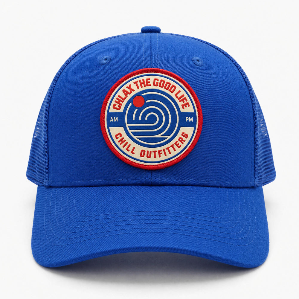 A royal blue trucker hat with a curved brim and mesh back panels, featuring a circular embroidered patch on the front that reads 'Chlax the Good Life Chill Outfitters' with a blue spiral logo.