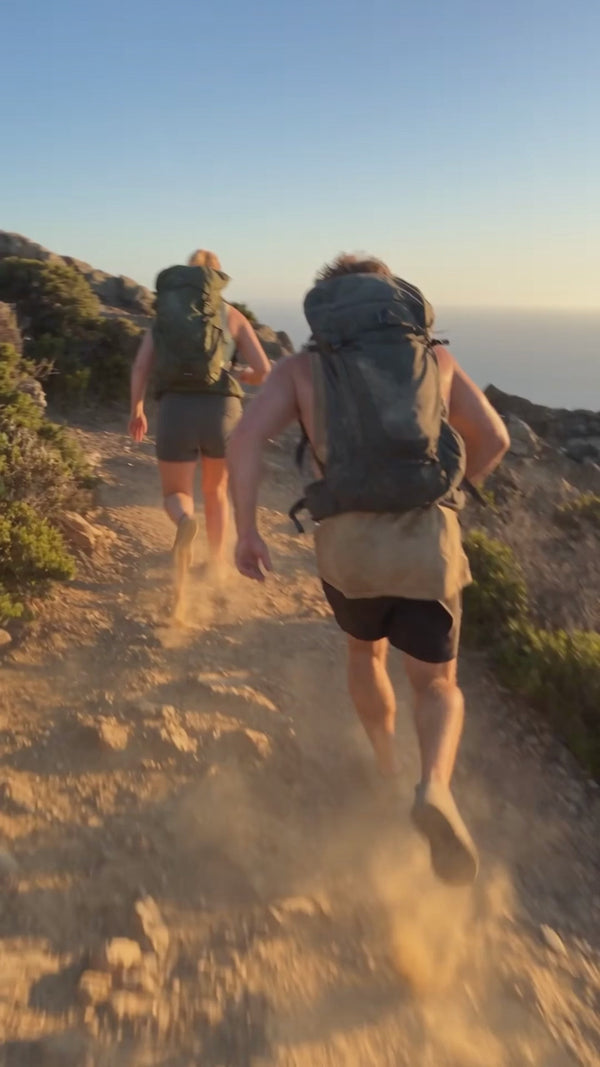 Two people running and hiking then jumping on the beach and grabbing cold drinks from an esky.